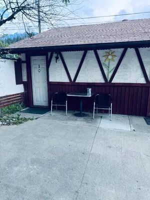 a house with two chairs and a table in front of it at Sunset Motel in Radium Hot Springs