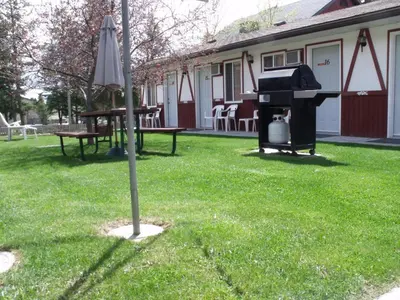 a lawn with a piano and a table and an umbrella at Sunset Motel in Radium Hot Springs