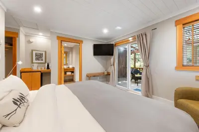 a bedroom with a large white bed and a window at West Coast Wilderness Lodge in Egmont