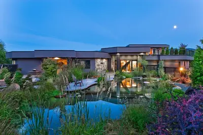 a house with a pond in front of it at Inn the Estuary in Nanoose Bay