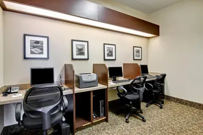 an office with three desks with computers and chairs at Canalta Camrose in Camrose
