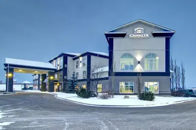 a building with a sign on the side of it at Canalta Camrose in Camrose