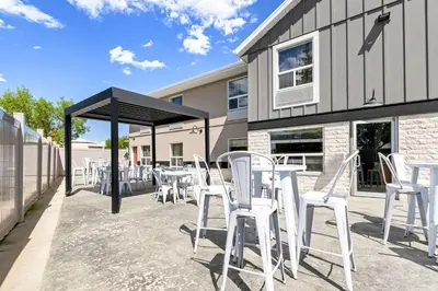 a group of white chairs and tables on a patio at SureStay Plus Hotel by Best Western Drumheller in Drumheller