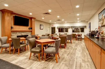 a restaurant with tables and chairs and a bar at Canalta Jurassic - Drumheller in Drumheller