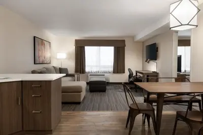 a living room and dining room with a couch and a table at Canalta Airdrie in Airdrie