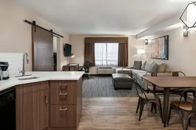 a kitchen and living room with a couch and a table at Canalta Airdrie in Airdrie