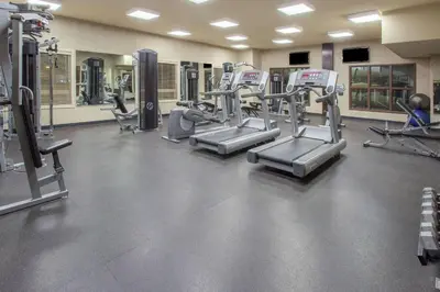 a gym with several treadmills and elliptical machines at Ramada by Wyndham Camrose in Camrose