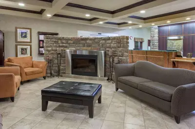 a living room with a fireplace and couches at Ramada by Wyndham Camrose in Camrose