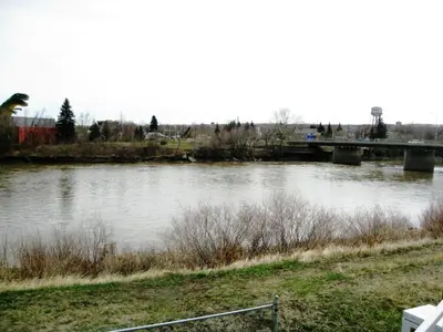 a view of a river with a bridge in the background at Travelodge by Wyndham Drumheller AB in Drumheller