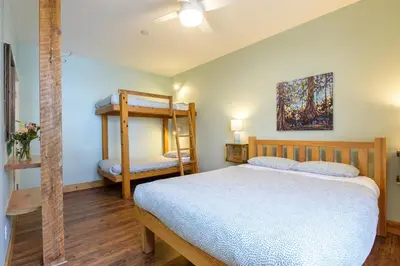 a bedroom with a bed and two bunk beds at Riding Fool Accommodation in Cumberland