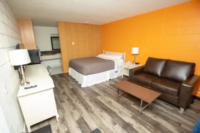a hotel room with a bed and a couch at Camrose Motel in Camrose