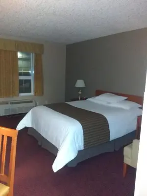 a bedroom with a large bed and a window at Econo Lodge in Okotoks