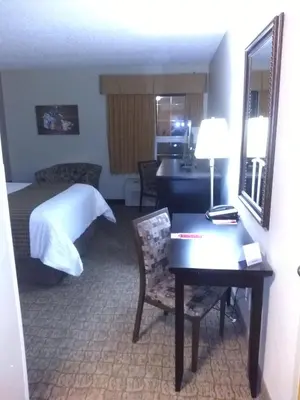 a hotel room with a desk and a bed at Econo Lodge in Okotoks