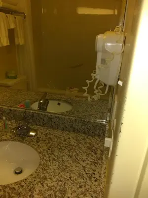 a bathroom with a sink and a toilet paper dispenser at Econo Lodge in Okotoks