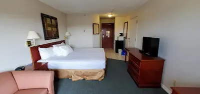 a hotel room with a bed and a television at Travelodge by Wyndham Stony Plain in Stony Plain