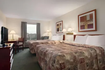 a hotel room with two beds and a television at Travelodge by Wyndham Stony Plain in Stony Plain