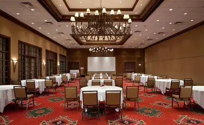 a conference room with tables and chairs and a chandelier at Red Deer Resort & Casino in Red Deer