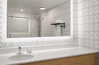 a white bathroom with a sink and a mirror at Sternwheeler Hotel & Conference Centre, Trademark by Wyndham in Whitehorse