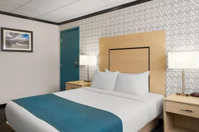 a bedroom with a large bed and a blue door at Sternwheeler Hotel & Conference Centre, Trademark by Wyndham in Whitehorse