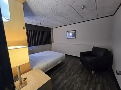 a small room with a bed and a chair at Sternwheeler Hotel & Conference Centre, Trademark by Wyndham in Whitehorse