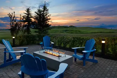 a group of blue chairs around a table with a fireplace at Courtyard by Marriott Calgary Airport in Calgary