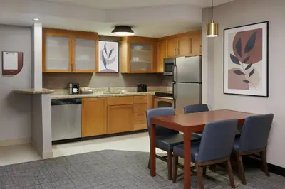 a kitchen with a wooden table and chairs at Residence Inn by Marriott Calgary Airport in Calgary