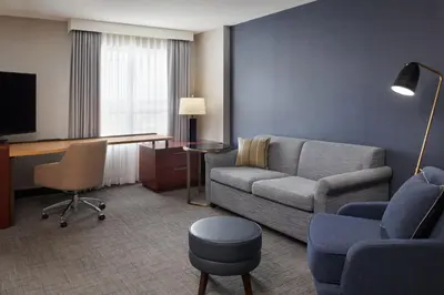 a living room with a couch and a chair and a desk at Residence Inn by Marriott Calgary Airport in Calgary