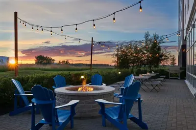 a patio with chairs and a fire pit at sunset at Residence Inn by Marriott Calgary Airport in Calgary