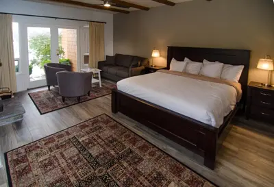 a bedroom with a large bed and a living room at Galiano Oceanfront Inn & Spa in Galiano
