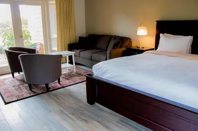 a bedroom with a bed and a living room with a couch at Galiano Oceanfront Inn & Spa in Galiano