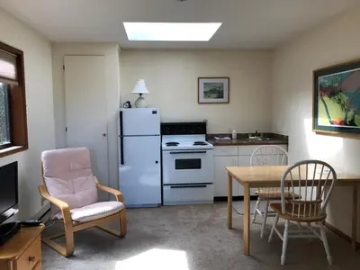a kitchen with a white refrigerator and a table and chairs at Driftwood Village Cottages in Sturdies Bay