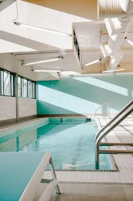 an indoor swimming pool with blue water in a building at Blue Horizon Hotel in Vancouver