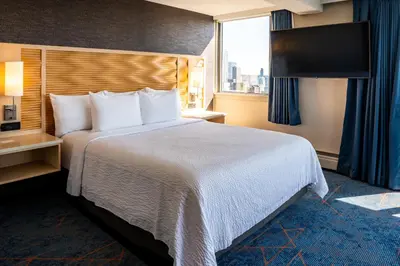 a hotel room with a large bed and a window at Blue Horizon Hotel in Vancouver