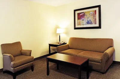 a hotel room with two chairs and a couch and a table at Holiday Inn Express Hotel & Suites - Slave Lake by IHG in Slave Lake