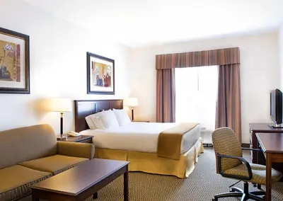 a hotel room with a bed and a couch at Holiday Inn Express Hotel & Suites - Slave Lake by IHG in Slave Lake