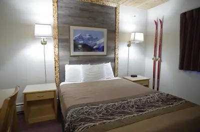 a hotel room with a bed and two lamps at Canadas Best Value Inn and Suites Fernie in Fernie