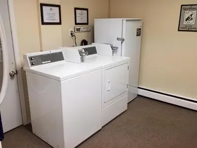 a kitchen with a refrigerator and a washing machine at Canadas Best Value Inn and Suites Fernie in Fernie