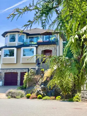 a large house with a tree at Eagle Rock Bed and Breakfast in Chemainus