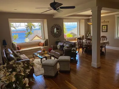 a living room with leather couches and a dining room at Eagle Rock Bed and Breakfast in Chemainus