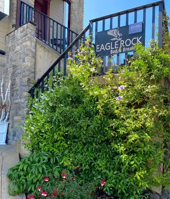 a sign for a gecko rock restaurant next to some plants at Eagle Rock Bed and Breakfast in Chemainus