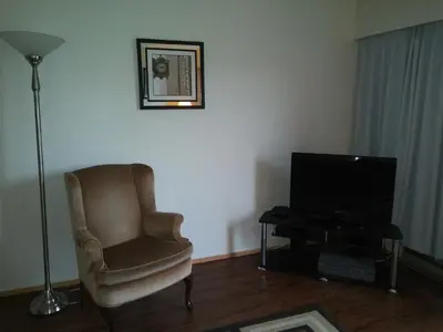 a living room with a chair and a television at Rosedale Manor in Duncan