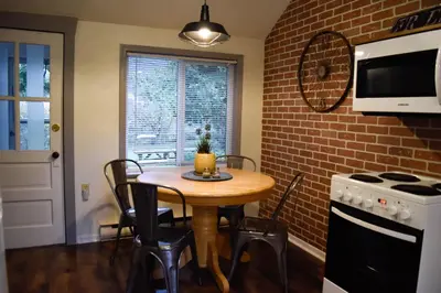 a kitchen with a table and a brick wall at Bramblebank Cottages in Harrison Hot Springs