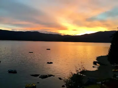a sunset on a lake with boats in the water at The Tuwanek Bed and Breakfast in Sechelt