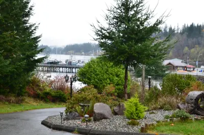 a garden with rocks and trees and a marina at High Point Resort in Quathiaski Cove