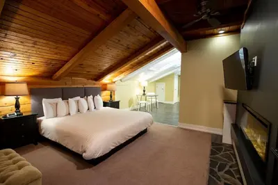 a bedroom with a large white bed and a tv at Banff Boutique Inn - Adults only in Banff