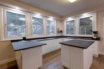 a large kitchen with white cabinets and windows at Banff Boutique Inn - Adults only in Banff