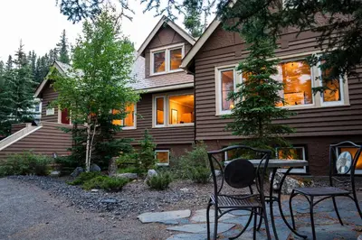 a house with two chairs and a table in front of it at Banff Boutique Inn - Adults only in Banff