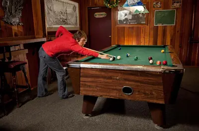 a woman playing a game of pool in a room at Heriot Bay Inn in Heriot Bay