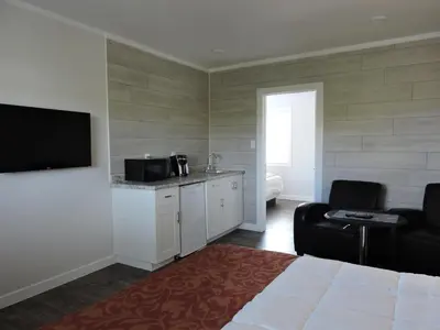 a hotel room with a bed and a tv and a kitchen at Almo Court Motel in Cranbrook