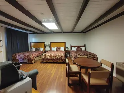 a room with two beds and a table and a couch at Kootenay Country Inn in Cranbrook